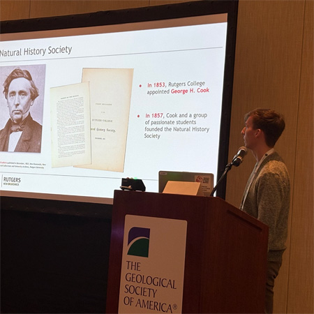 student at podium with screen in background